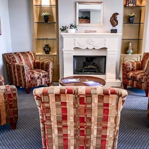 A living room with a fireplace and chairs.