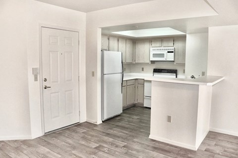 A kitchen with a refrigerator, microwave, and oven.
