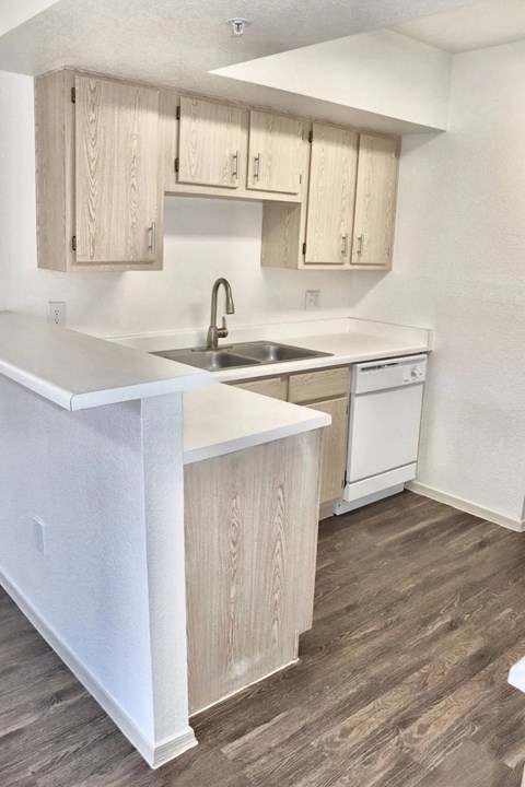 A kitchen with wooden cabinets and a white counter.
