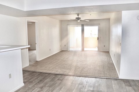 A spacious room with a ceiling fan and sliding glass doors.