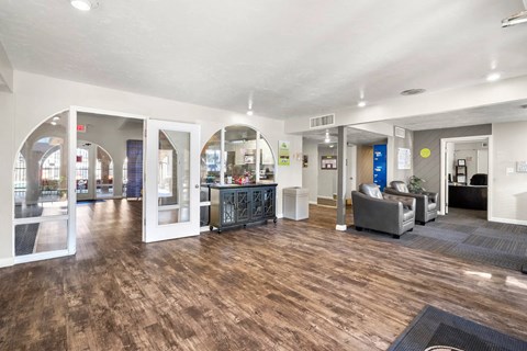 A spacious office lobby with a wooden floor and white walls.