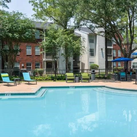 A swimming pool in front of apartment buildings.