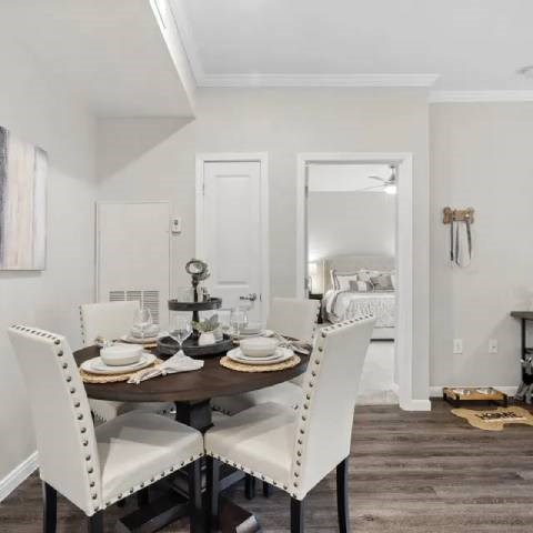 A dining room with a table set for four.