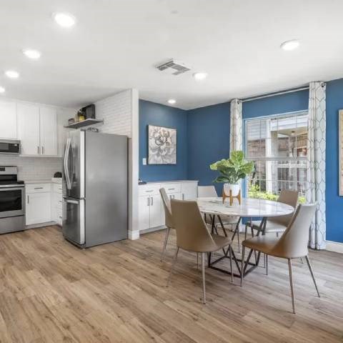 A modern kitchen with a dining table and chairs.