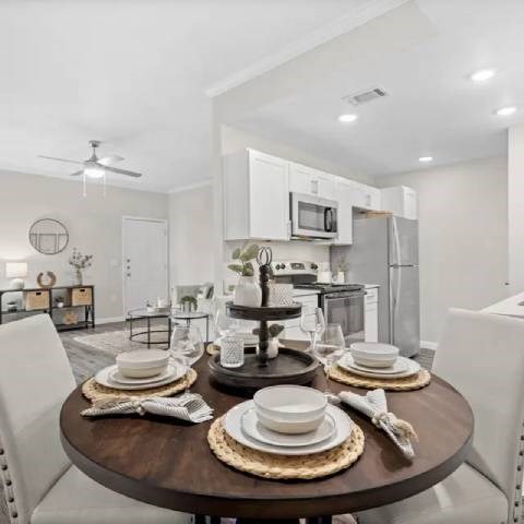 A modern dining room with a round table set for four.