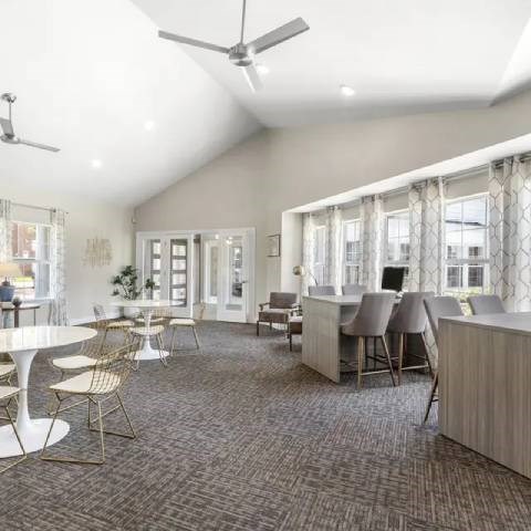 A spacious room with a carpeted floor and a ceiling fan.