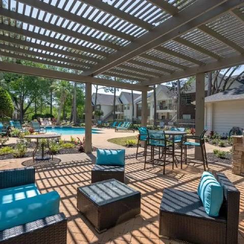 A patio with a table and chairs under a roof.