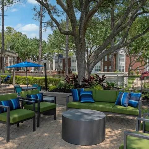 A patio with a green couch and a table.