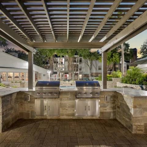 A modern outdoor kitchen with a grill and sink.