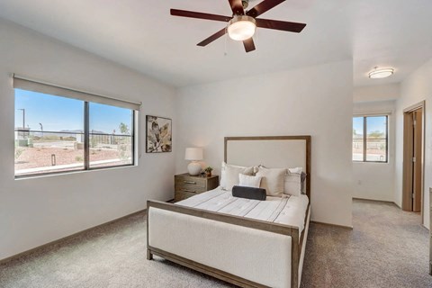 A bedroom with a large bed and a ceiling fan.
