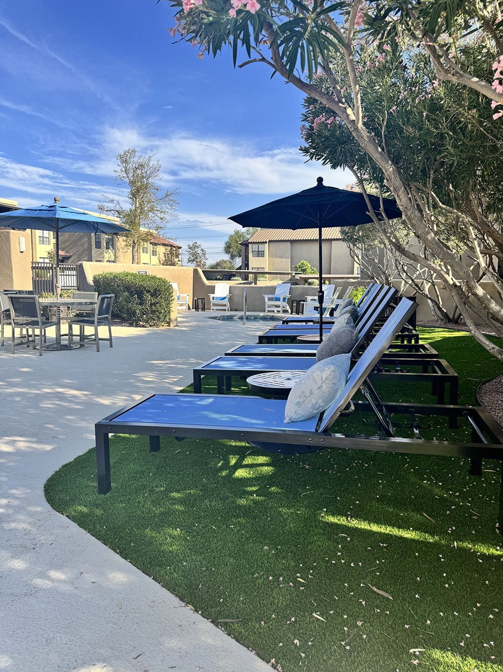 A sun lounger and table on a lawn.
