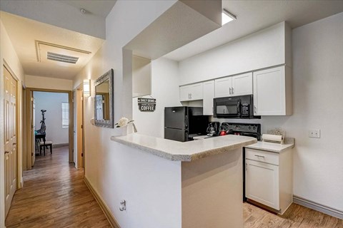 A kitchen with white cabinets and a counter.