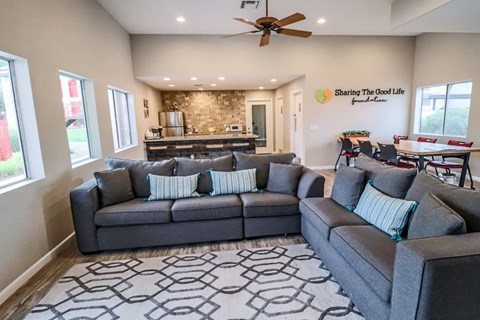 A living room with a grey couch and a stone wall in the background.