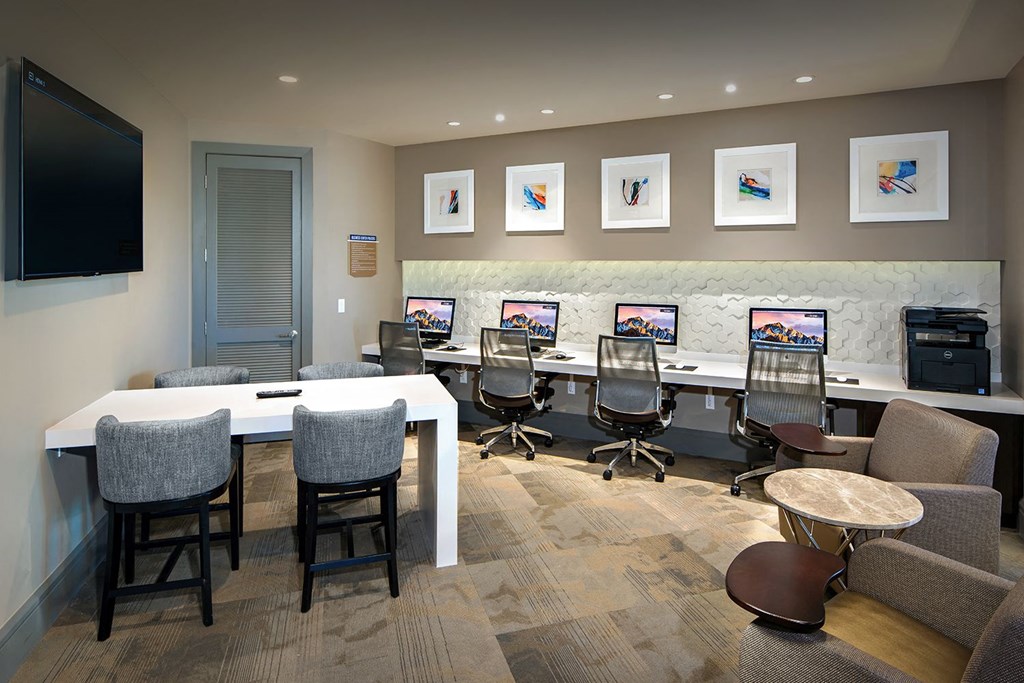 A conference room with a long table, chairs, and a television.
