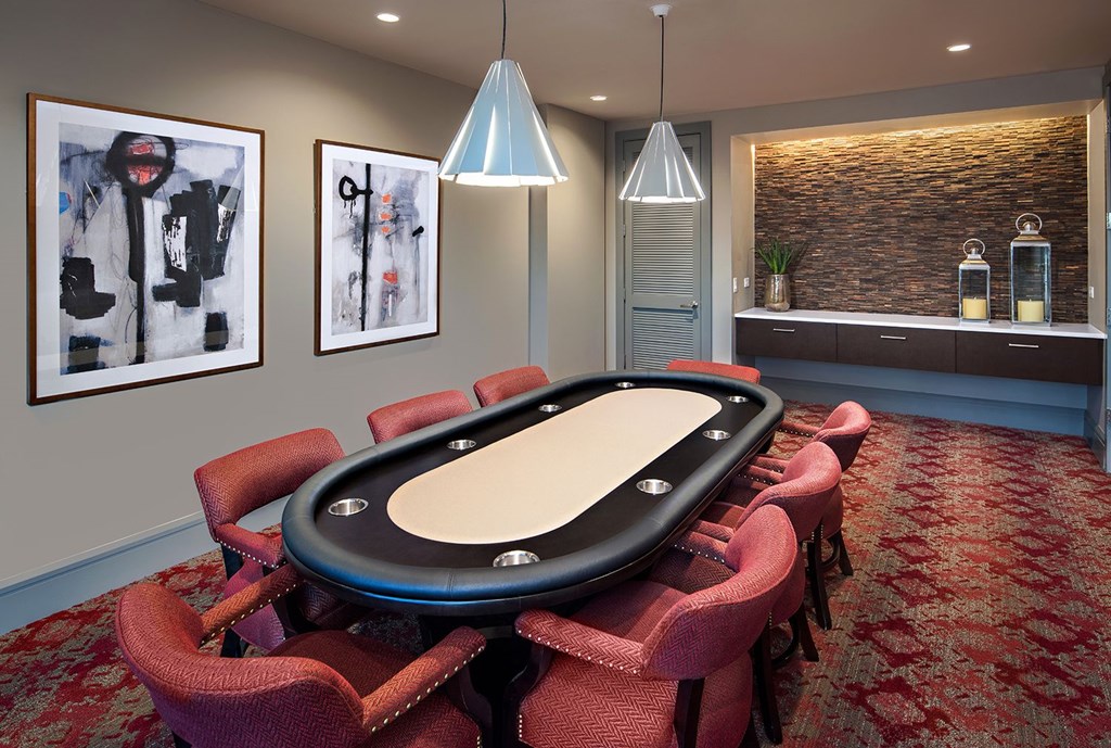 A poker table surrounded by chairs in a room.
