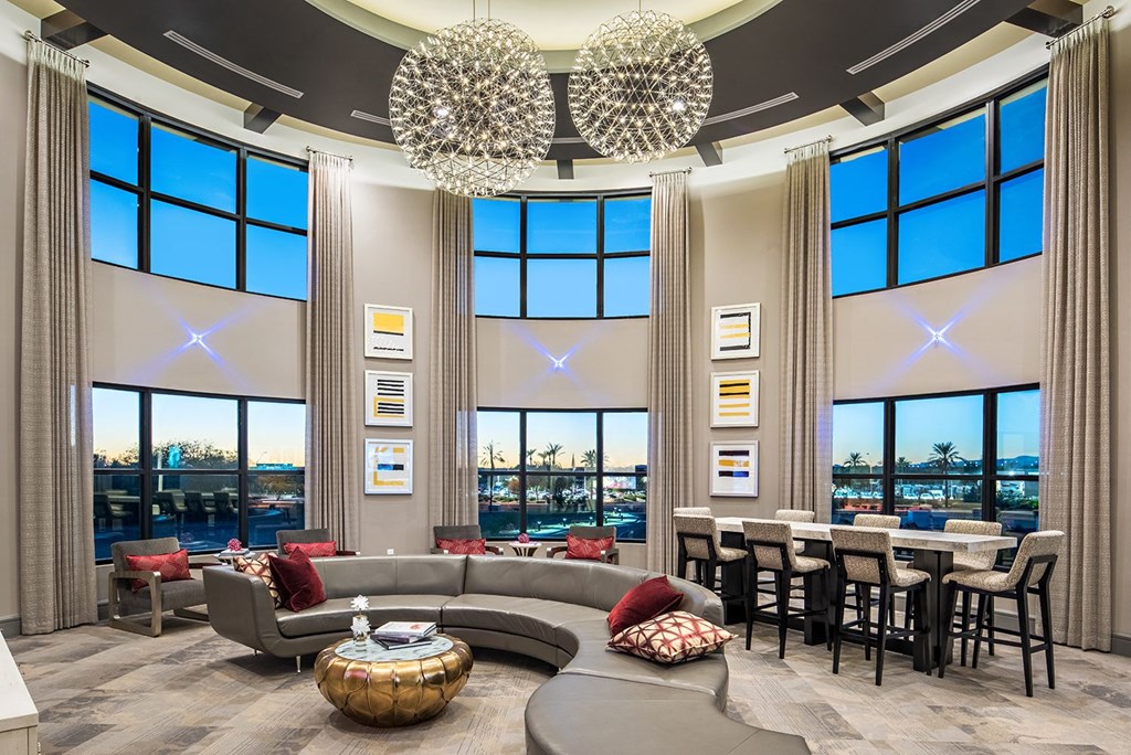 A modern living room with a large chandelier and a view of the city.