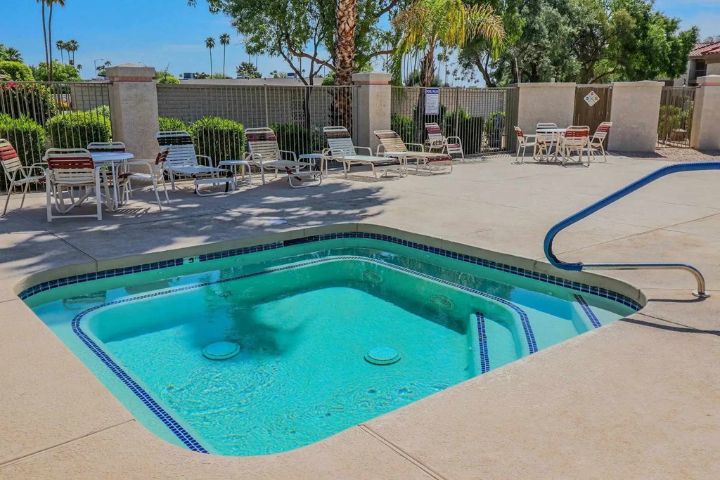 A person is swimming in a pool with a blue tiled edge.