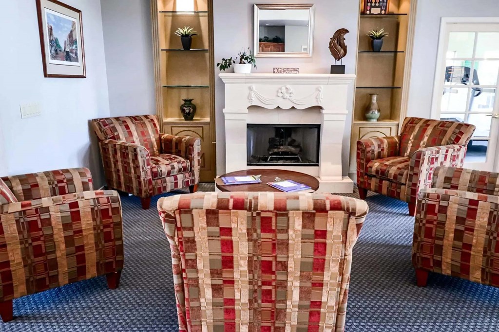A living room with a fireplace and chairs.