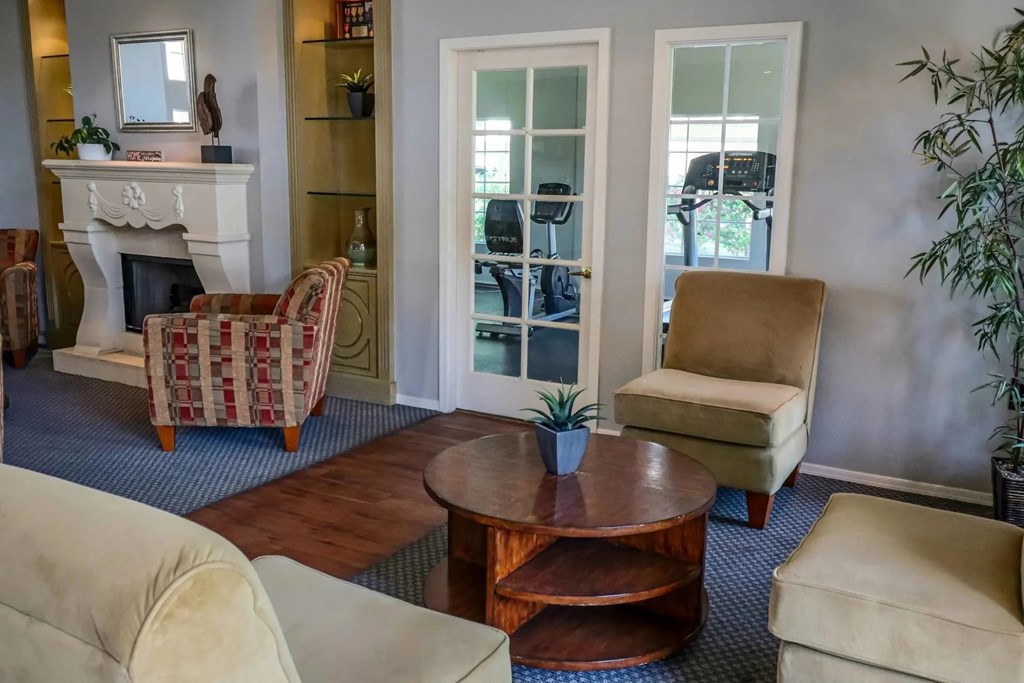 A living room with a fireplace, chairs, and a coffee table.