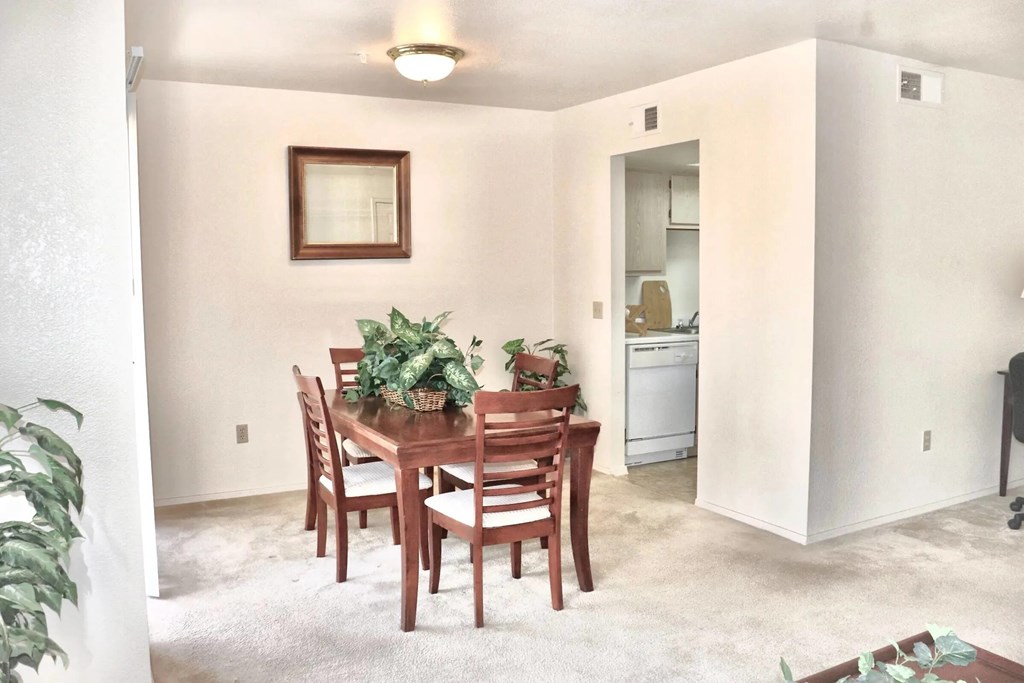 A dining room with a wooden table and chairs.