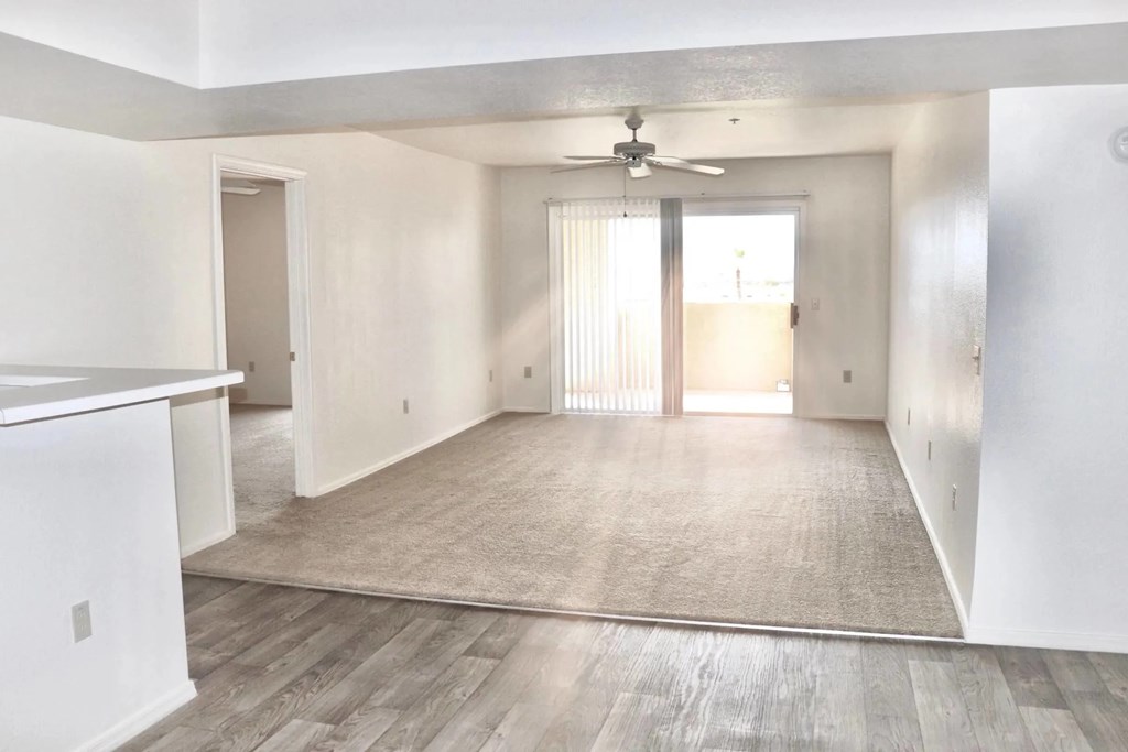 A spacious room with a ceiling fan and sliding glass doors.