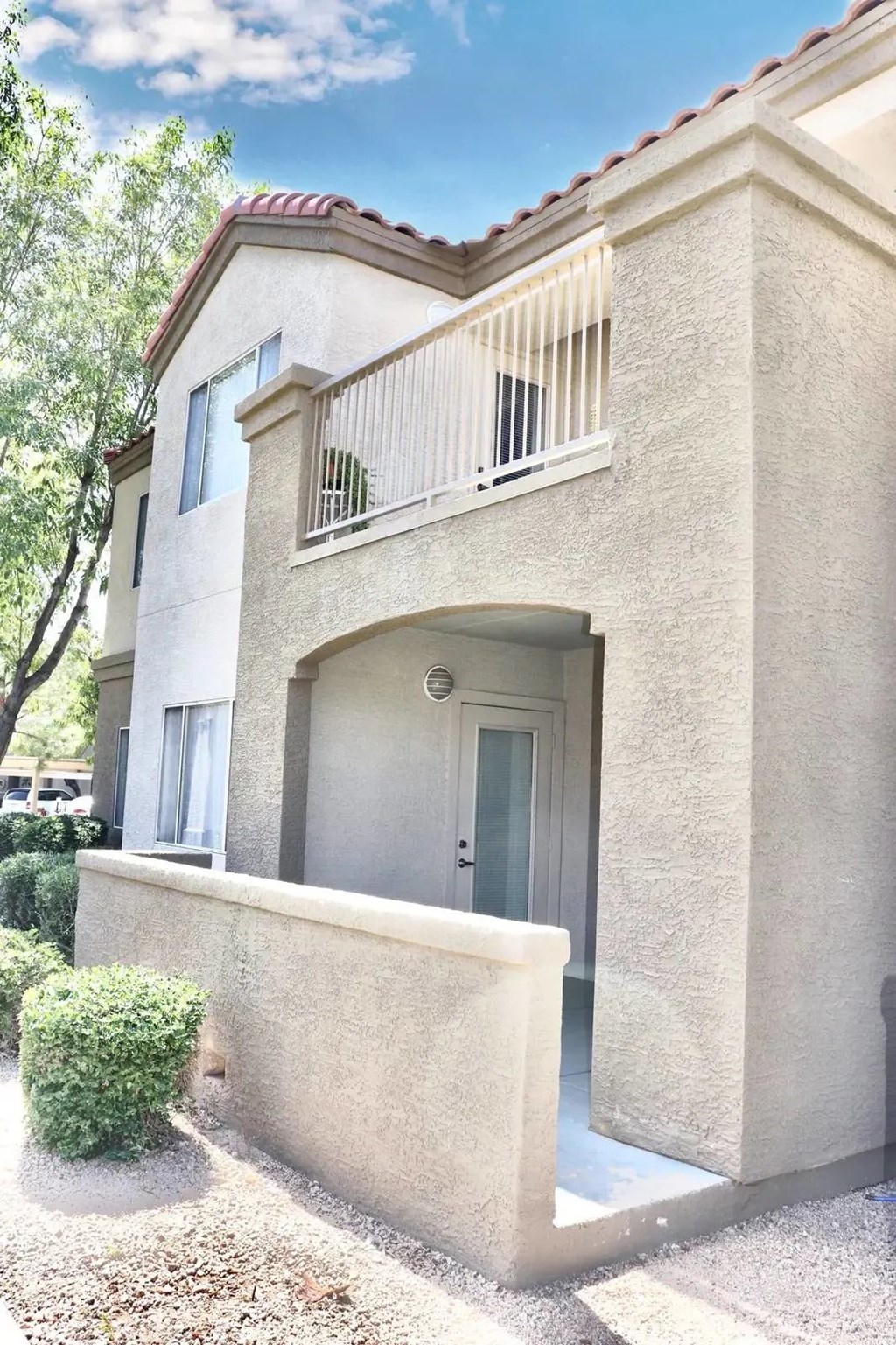 A beige house with a balcony and a door.