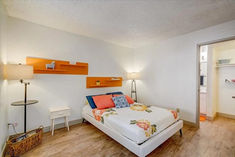 A bedroom with a bed, nightstands, and a lamp.