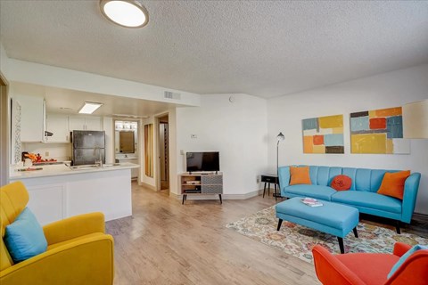 A living room with a yellow chair and a blue couch.