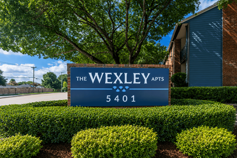 A sign for The Wexley Arts is in front of a building.