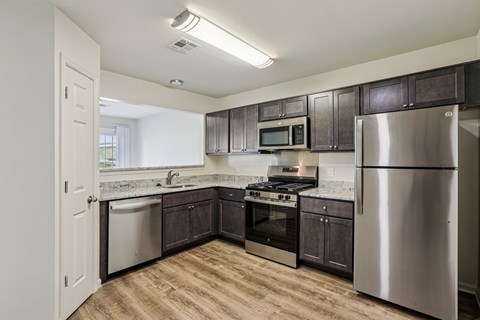 A kitchen with a stainless steel refrigerator, oven, and microwave.