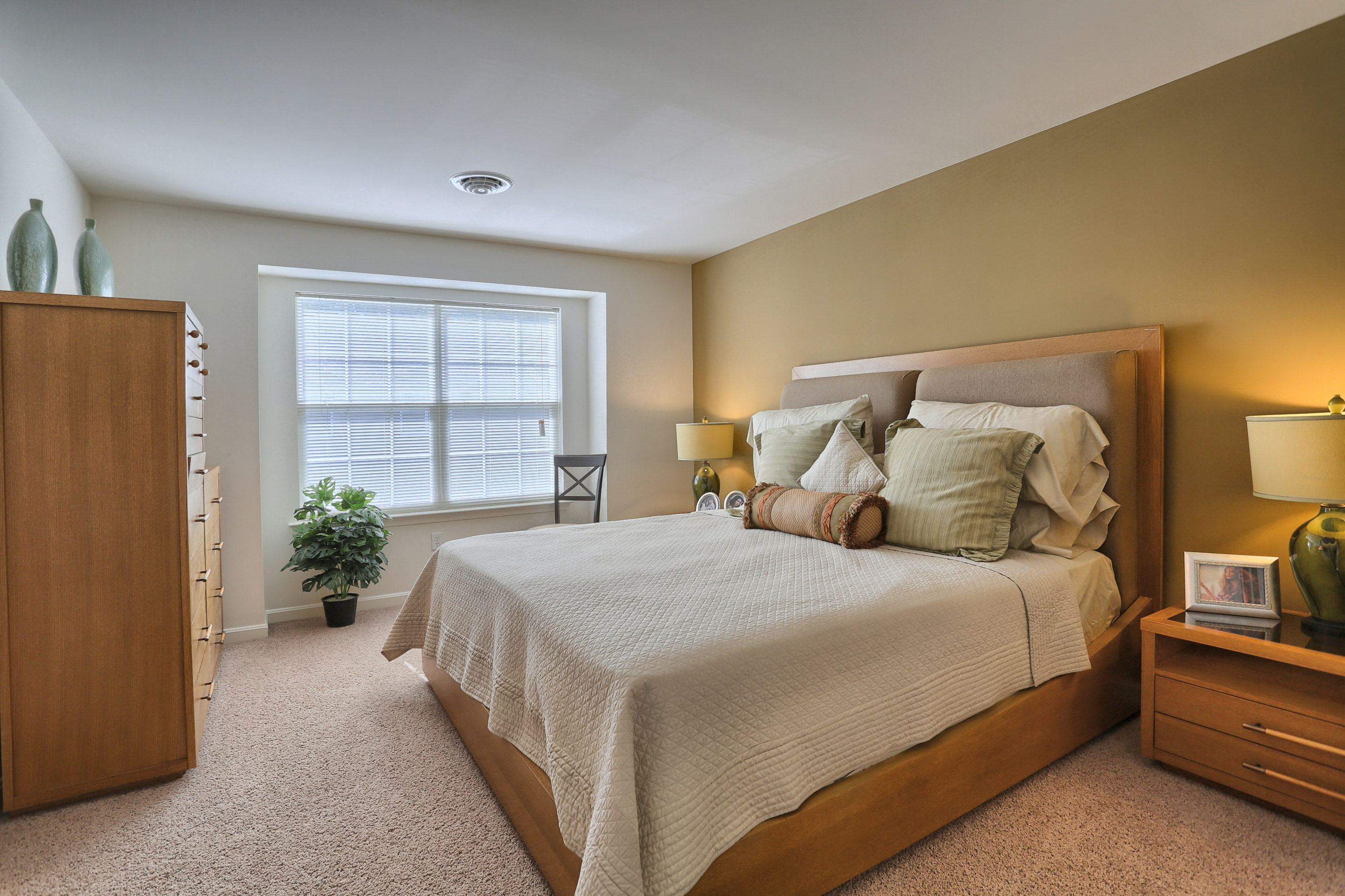 A bedroom with a large bed and a window.