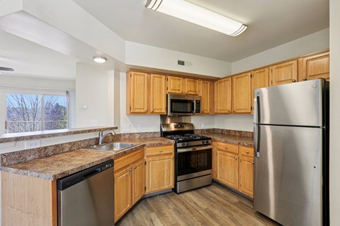 A kitchen with wooden cabinets and stainless steel appliances.