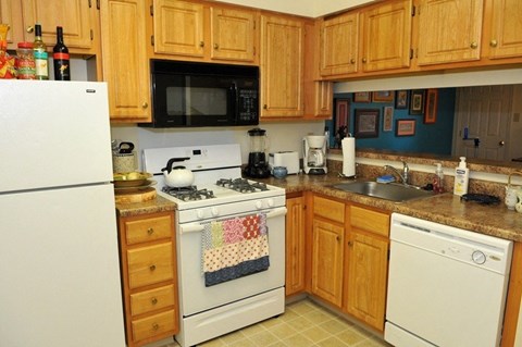 A kitchen with wooden cabinets and a white refrigerator.