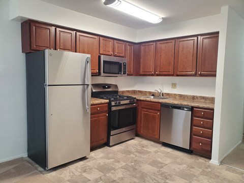 a kitchen with stainless steel appliances and wooden cabinets