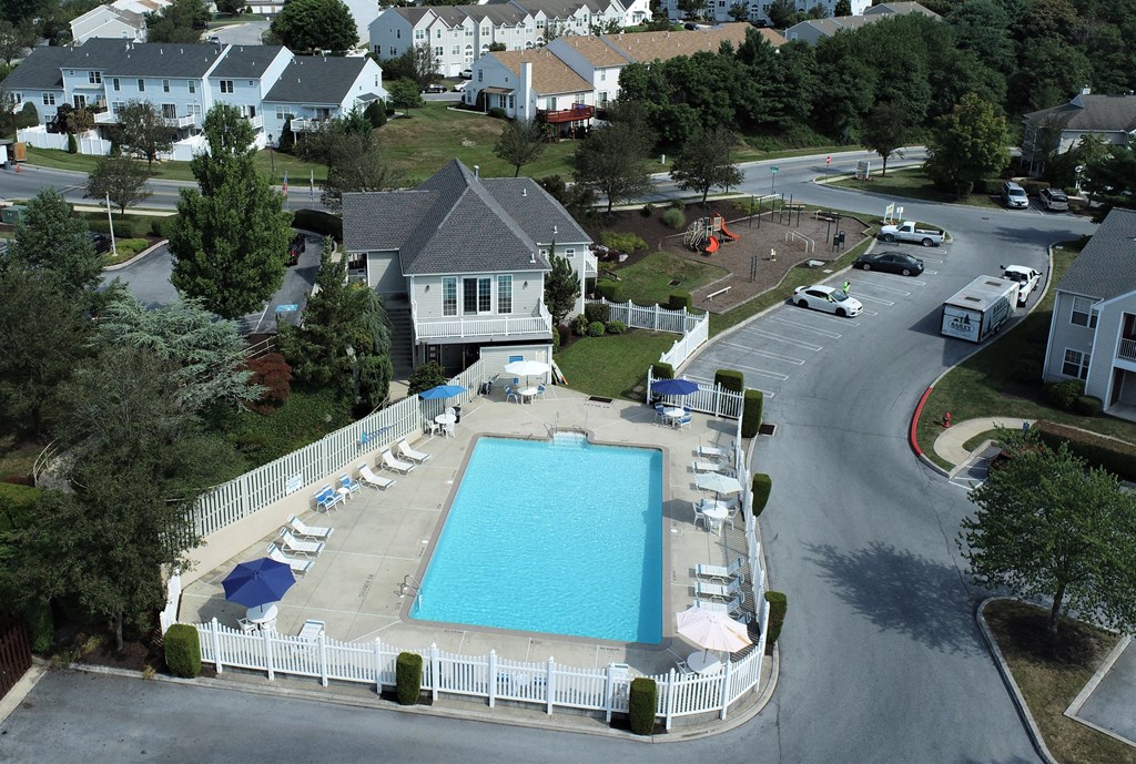 an aerial view of a swimming pool in front of a house