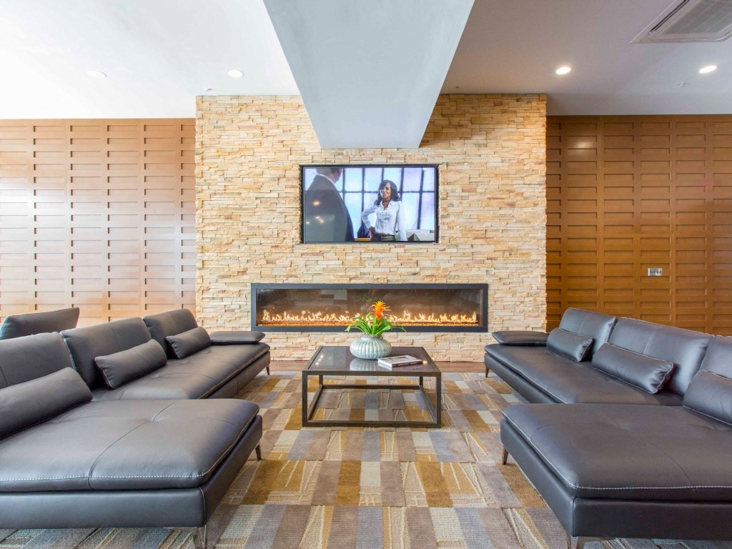 The resident lounge with comfortable seating, TV, and gas fireplace