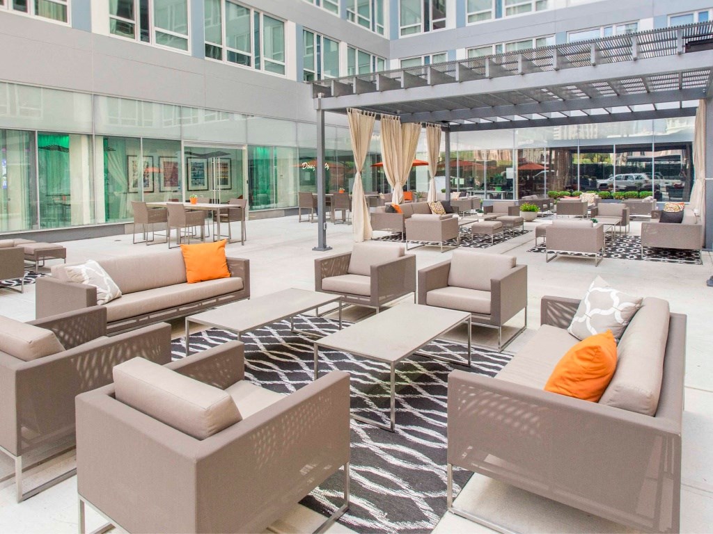 The resident courtyard features comfortable seating arrangements, conversation areas, and fire pits