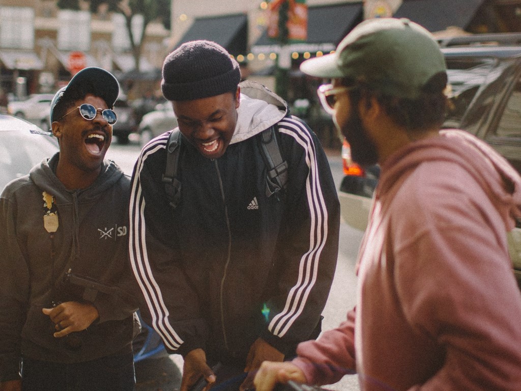 Three residents enjoy a conversation outdoors near Kardon Atlantic
