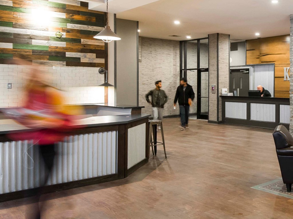 Residents enter the Kardon Atlantic lobby while an attendant works at the front desk