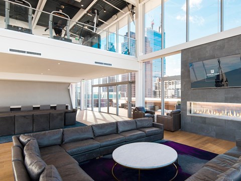 A modern living room with a large grey sofa and a white coffee table.