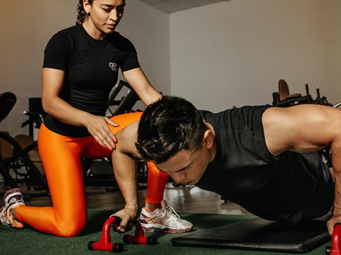 a man and a woman doing pushups in a gym