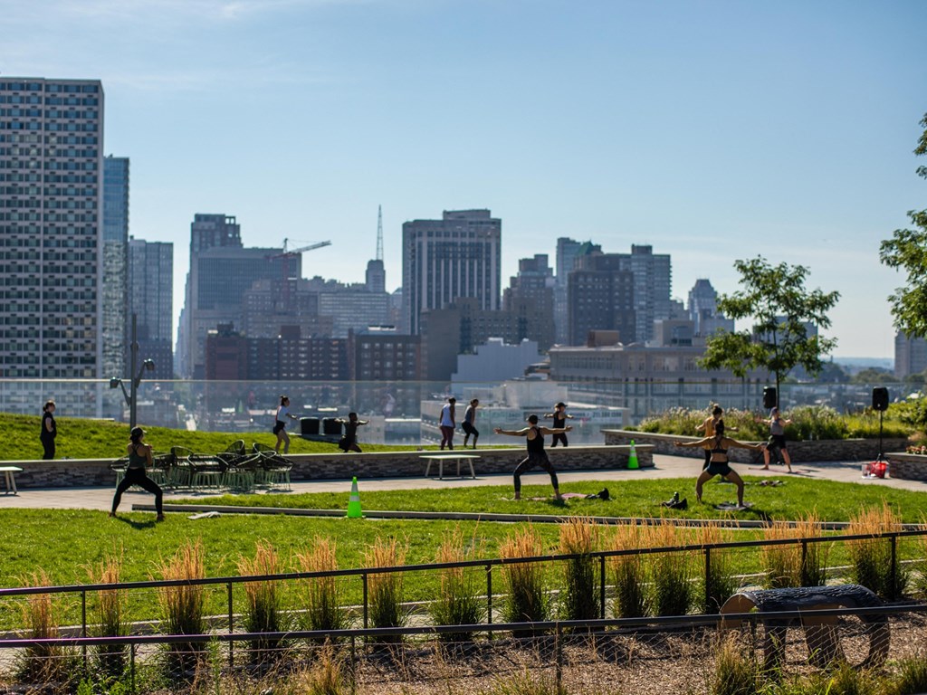 a group of people doing yoga outside on the river trail