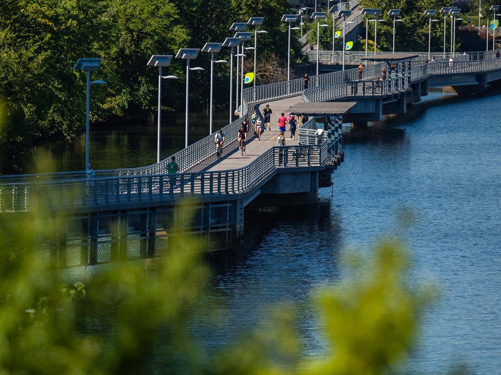 people running and biking along the river trail