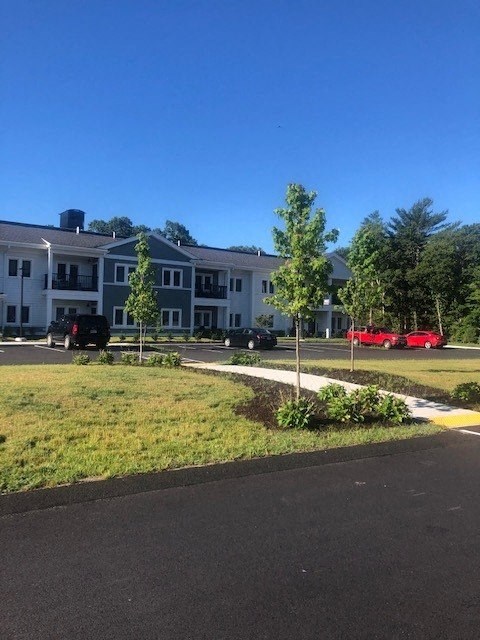 a large apartment complex with cars parked in front of it