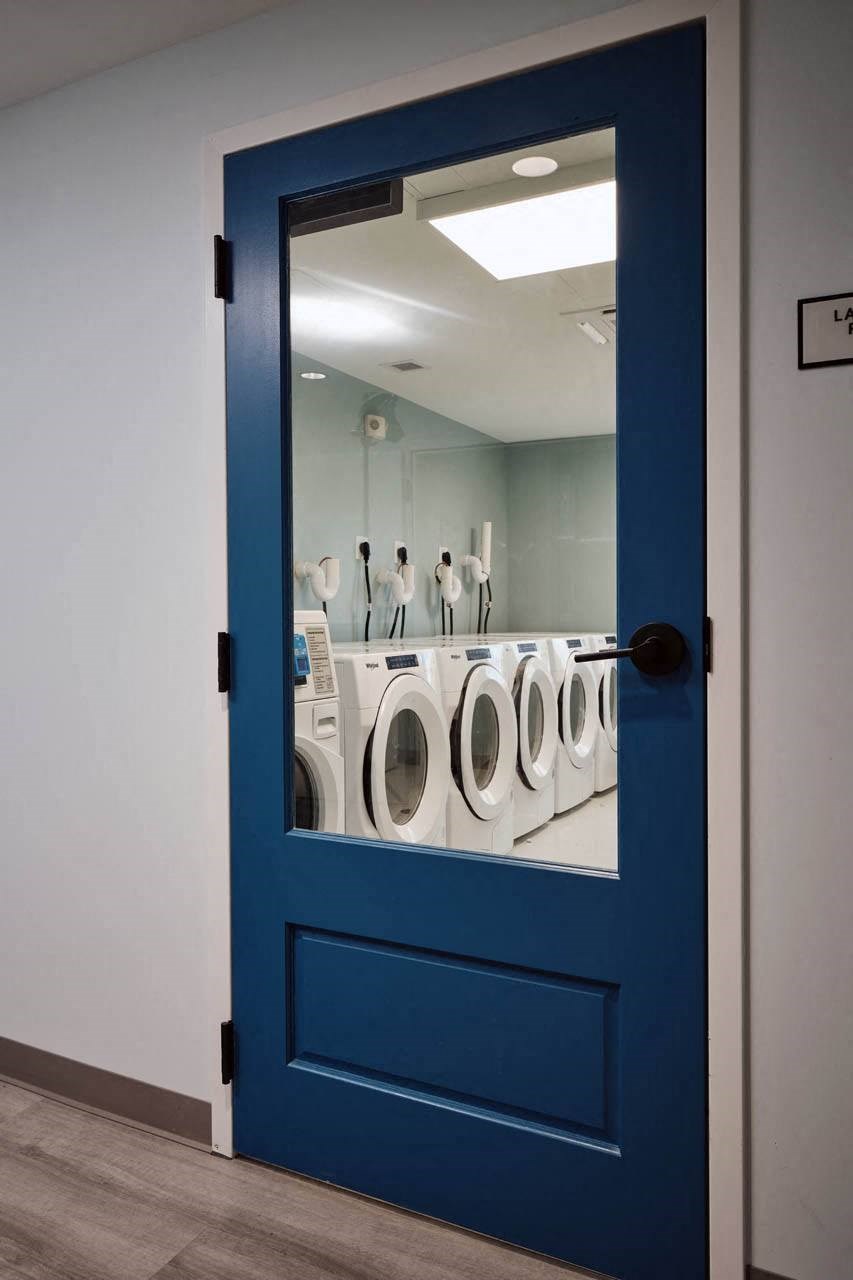 a blue door with a mirror in a laundromat
