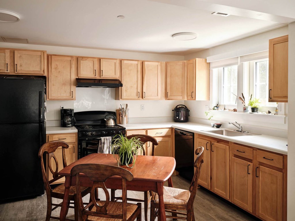 a kitchen with wooden cabinets and a wooden table and chairs