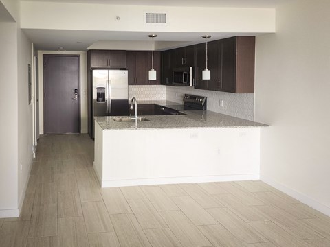 an empty kitchen with a counter top and a refrigerator at Meridian Point at Goulds Station in Miami, FL, 33170