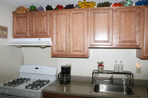 A kitchen with a white stove and wooden cabinets.