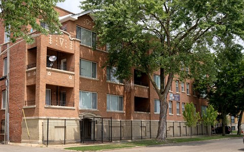 a red brick building with a tree in front of it