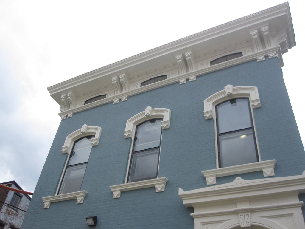 the side of a blue building with three windows